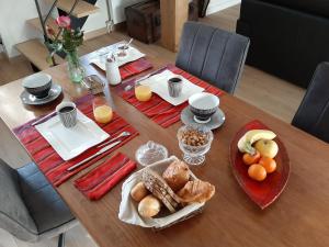 a table with breakfast foods and orange juice on it at Le Refuge du Hibou in Beaurains