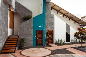 a house with a blue door and stairs on it at HOTEL AYRE By Baltra in Puerto Ayora