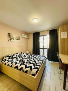 um quarto com uma cama, uma mesa e uma janela em Urban Life Tirana- Economy Rooms em Tirana