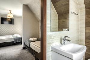 łazienka z umywalką i łóżkiem w pokoju w obiekcie Willa Biały Domek w Zakopanem