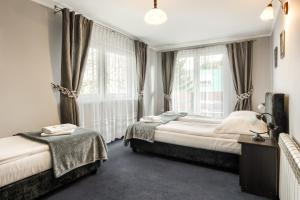 una camera da letto con due letti e una finestra di Willa Biały Domek - 600m Krupówki a Zakopane