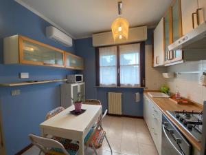 a kitchen with blue walls and a table and chairs at Chicco Light - Appartamento low cost per soggiorni brevi Vercelli Wi-Fi - Cinelli Apartment in Vercelli