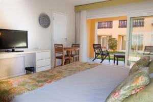 una camera con letto, TV e tavolo di Búzios Beach Resorts a Búzios Altre 2 foto
