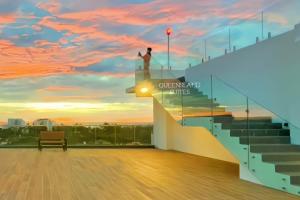 亞庇的住宿－QUEENSLAND SUITES at Aru Suites, Kota Kinabalu，一位在楼梯间顶端的男人,伴着日落