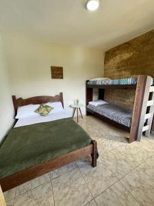 a bedroom with a bed and bunk beds in it at HOSTEL DA LAPINHA in Santana do Riacho
