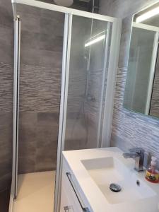 a bathroom with a shower and a white sink at Appartement F3 de 60M² à 20 minutes de Paris. in Yerres