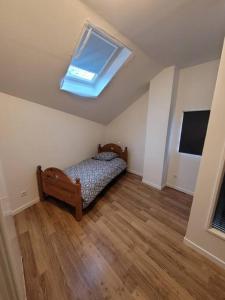 ein Schlafzimmer mit einem Bett und einem Dachfenster in der Unterkunft Appartement F3 de 60M² à 20 minutes de Paris. in Yerres