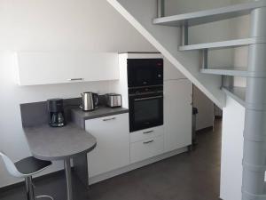 a white kitchen with a stove and a counter top at Appartement F3 de 60M² à 20 minutes de Paris. in Yerres