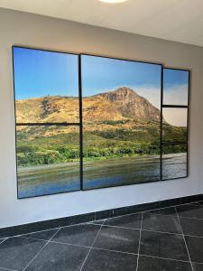 a room with three windows with a view of a mountain at San Diego Governador Valadares in Governador Valadares