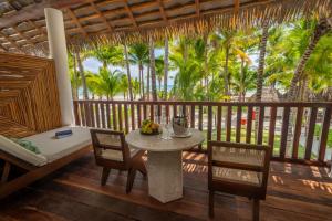 una sala da pranzo con tavolo, sedie e palme di El Dorado Maroma Catamarán, Cenote & More Inclusive a Playa del Carmen