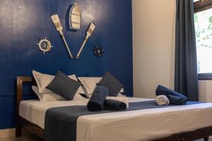 a bedroom with a bed with blue walls and a clock on the wall at Captal Beach Villa in Mathiveri