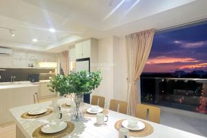 亞庇的住宿－QUEENSLAND SUITES at Aru Suites, Kota Kinabalu，厨房以及带桌子和窗户的用餐室。