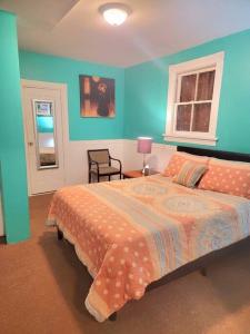 1 dormitorio con cama y pared azul en King Bed, Private Entrance, Gym, and free water!, en Yonkers