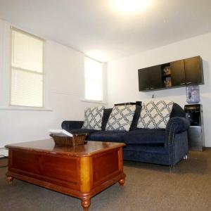 een woonkamer met een blauwe bank en een salontafel bij King Bed, Private Entrance, Gym, and free water! in Yonkers