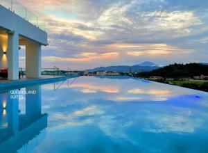 a pool on the roof of a building with a cloudy sky at QUEENSLAND SUITES at Aru Suites, Kota Kinabalu in Kota Kinabalu