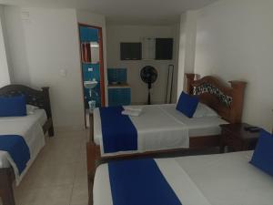 a hotel room with two beds and a sink at hotel koral palmira in Palmira