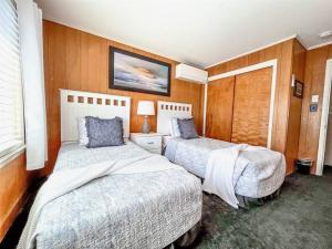 two beds in a room with wood paneling at Ocean front * Boardwalk * Private Balcony in Ocean City