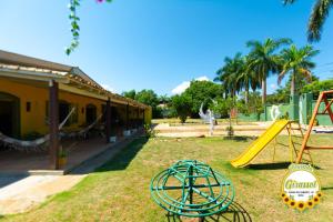 einen Garten mit Rutsche und Spielplatz in der Unterkunft Pousada Girassol in Chapada dos Guimarães