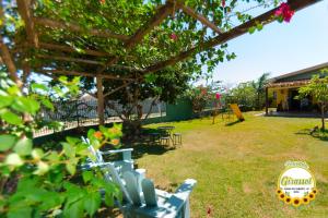 a garden with chairs and tables in a yard at Pousada Girassol in Chapada dos Guimarães