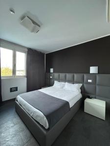 a bedroom with a large bed with a black wall at Hotel Noventa in Noventa Vicentina