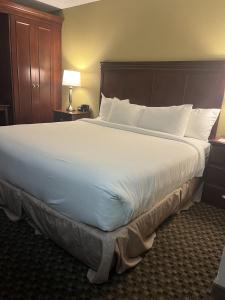 een groot wit bed in een hotelkamer bij Woodmen Inn in Colorado Springs