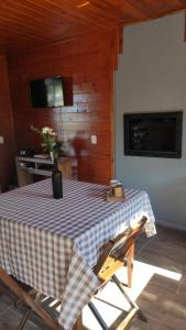 a room with a table with a vase of flowers on it at Refúgio das Uvas * Casa do Lago in Frederico Westphalen