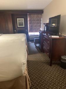 a hotel room with two beds and a desk and a television at Woodmen Inn in Colorado Springs