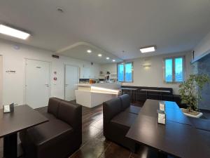 a living room with two tables and a kitchen at Hotel Noventa in Noventa Vicentina