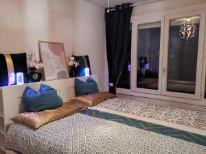 Habitación con 2 camas con almohadas y ventana en Chambre Cozy avec Vue Panoramique sur la Seine, Proche de Paris et de l'Aéroport Orly, en Choisy-le-Roi