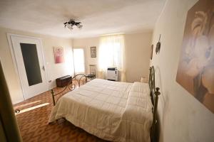 a bedroom with a white bed in a room at CASA LETIZIA in Ozzano Monferrato