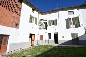 uma vista exterior de um edifício branco com persianas verdes em CASA LETIZIA em Ozzano Monferrato