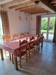 uma mesa de jantar com uma toalha de mesa xadrez vermelha e branca em Diksmuidse Ardennen 