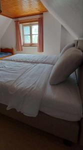1 cama blanca con almohadas en el dormitorio en Diksmuidse Ardennen 