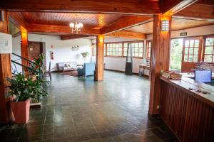 una gran sala de estar con techos de madera y un vestíbulo en Recanto das Hortencias Hotel, en Monte Verde