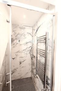 a bathroom with a shower with a marble wall at Cosy hillside cottage in Great Malvern
