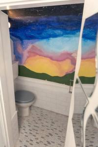a bathroom with a toilet and a painting on the wall at Cosy hillside cottage in Great Malvern +18 photos