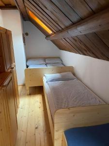 twee bedden in een kleine kamer met een houten plafond bij Ferienhaus Werkstattl Rassis Feriendorf Donnersbachwald in Donnersbachwald