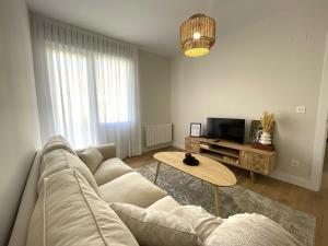 sala de estar con sofá y mesa en ByAndreea Apartaments EtxeBat, en Guernica y Luno