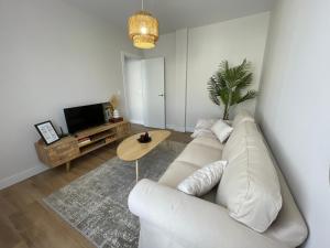 sala de estar con sofá blanco y mesa en ByAndreea Apartaments EtxeBat, en Guernica y Luno