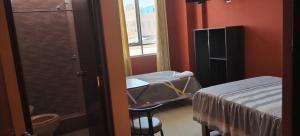 una camera con un letto, un lavandino e una finestra di HOSTAL LLAUT * * a Moquegua