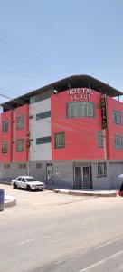 un grande edificio rosso e bianco con un parcheggio di HOSTAL LLAUT * * a Moquegua