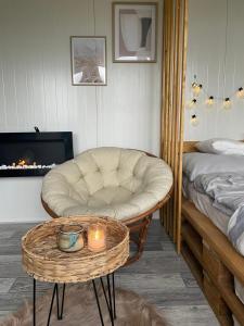 een woonkamer met een stoel en een tafel met een kaars bij Sidehill - zážitkové ubytovanie v prírode in Martin