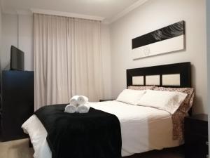 a bedroom with a bed with a teddy bear on a table at Apartamento La Muralla II in Baena