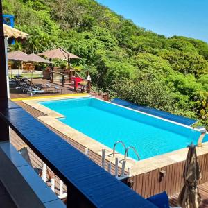 a swimming pool at a resort with a mountain in the background at Top de Buzios Boutique Hotel & Spa in Búzios
