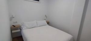 sypialnia z białym łóżkiem i poduszką w obiekcie Calesapart2 Brisa Marina w mieście Candelaria