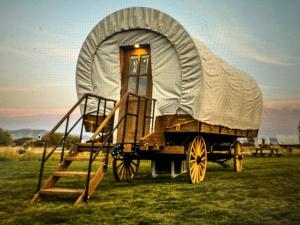 a wagon with a tent on it in a field at Eycat Lodging Company in Wapiti