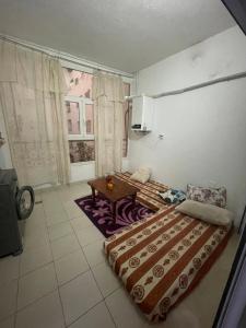sypialnia z 2 łóżkami, stołem i oknem w obiekcie Molk w mieście Manūbah