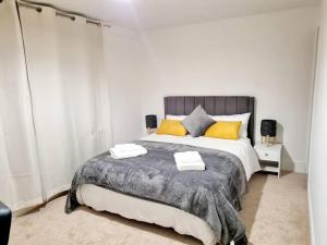 a bedroom with a large bed with yellow pillows at Cosy Luxurious 3 Bedroom House, Free Parking, Free WiFi, Private Garden, Free Netflix in Havering atte Bower