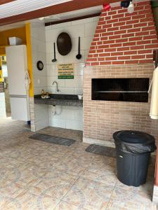cocina con horno de ladrillo y cubo de basura en Residencial da Praia, en Florianópolis