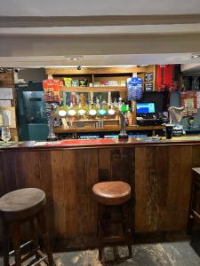 un bar con dos taburetes sentados en el bar en The kings head, en Chacewater